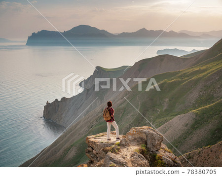 A young Asian woman with a backpack hiking in the summer. A young Asian woman with a backpack hiking in the summer. 78380705