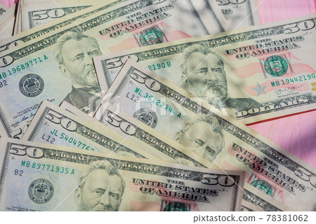 Closeup American cash banknotes. Dollars on a pink wooden background. Finance concept. Closeup American cash banknotes. Dollars on a pink wooden background. Finance concept. 78381062