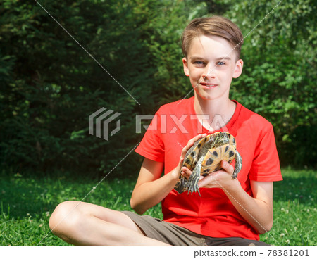Teen boy with turtle outdoor focus on turtle Teen boy with turtle outdoor focus on turtle 78381201