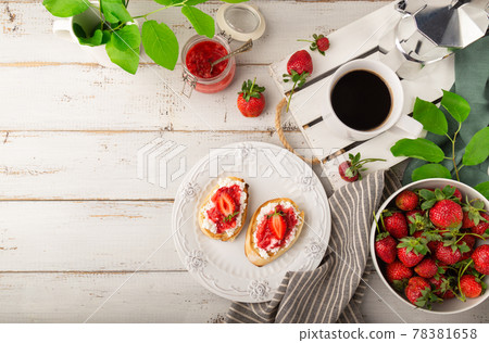 Homemade bruschetta with cottage cheese and strawberries for breakfast at white wooden background 78381658