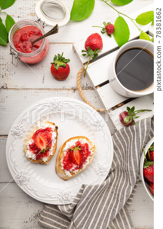 Homemade bruschetta with cottage cheese and strawberries for breakfast at white wooden background 78381662
