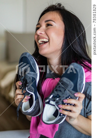 Happy woman rejoice holding new sneakers having fun and positive emotion. Sale discount buying 78381829