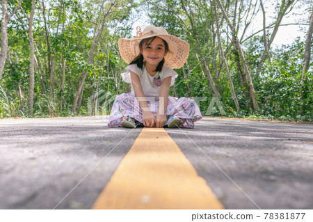 little girl sitting on the middle of asphalt road little girl sitting on the middle of asphalt road 78381877