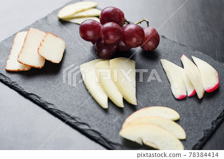 gourmet mixed cheese board tapas starter with apple and grapes 78384414