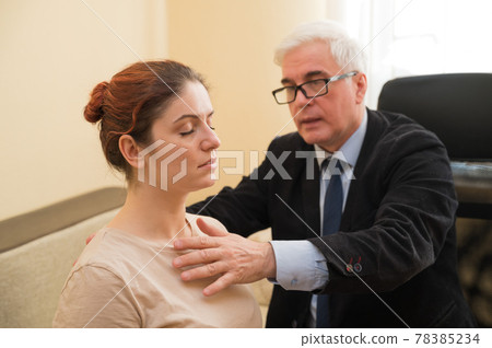 Mature gray-haired man hypnotizes Caucasian woman during hypnotherapy session. The psychologist uses alternative treatments for the subconscious mind Mature gray-haired man hypnotizes Caucasian woman during hypnotherapy session. The psychologist uses alternative treatments for the subconscious mind 78385234