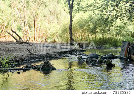 environmental pollution; garbage in the bed of the small river and the bank poisoned by industrial effluents environmental pollution; garbage in the bed of the small river and the bank poisoned by industrial effluents 78385585