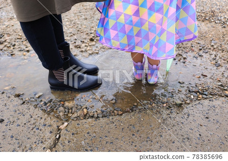 六月雨季兒童和媽媽的靴子進入水坑 六月雨季兒童和媽媽的靴子進入水坑 78385696