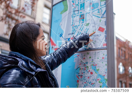 Mexican woman checking city map in downtown Vancouver Mexican woman checking city map in downtown Vancouver 78387509