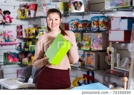 Adult woman consumer with color box among children's toys in the store 78388890