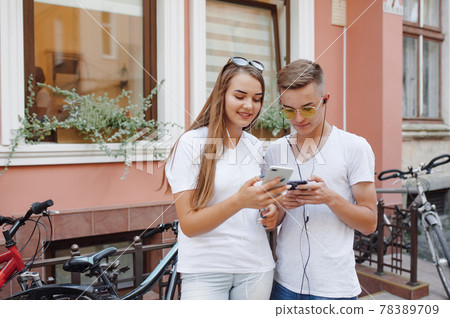 Couple standing in a city with mobile phone Couple standing in a city with mobile phone 78389709