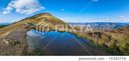 Small picturesque lake with clouds reflections at the  Strymba Mount. Beautiful autumn day in Carpathian Mountains near Kolochava village, Transcarpathia, Ukraine. 78389756