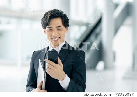 一位穿著西裝的商人在辦公室操作智能手機 78389887