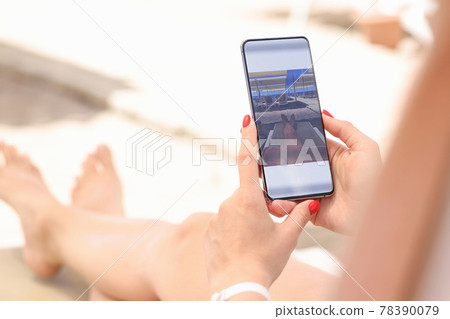 Woman is editing taken photo on smartphone 78390079