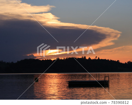 UFO shaped cloud with a sun beam shining trough. 78390812