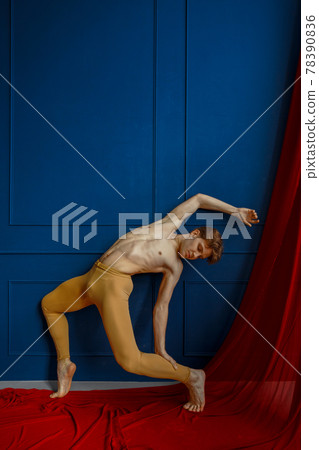 Ballet dancer poses at blue wall in dancing class 78390836