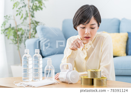 一位婦女在家裡檢查防災用品、疏散用品和應急食品的庫存 78391124