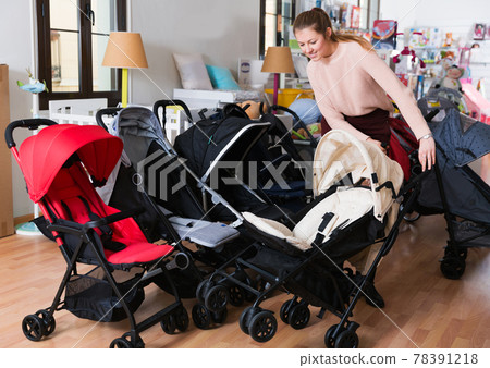 buyer choosing stroller cane in the shop 78391218