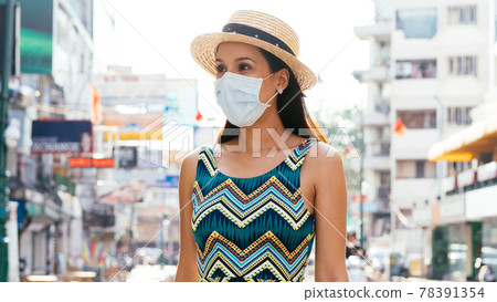 Young Mexican woman wearing face mask in city Young Mexican woman wearing face mask in city 78391354