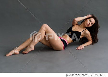 Posing fitness seductive woman isolated on grey background Posing fitness seductive woman isolated on grey background 78391613