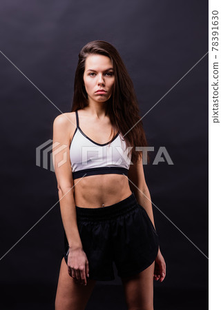 Posing fitness seductive woman isolated on grey background 78391630