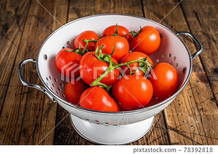 Branch of Red cherry tomatoes in colander. Wooden background. Top view Branch of Red cherry tomatoes in colander. Wooden background. Top view 78392818