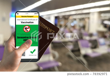 Traveler holds vaccine passport certificate to show COVID 19 vaccination status Traveler holds vaccine passport certificate to show COVID 19 vaccination status 78392971