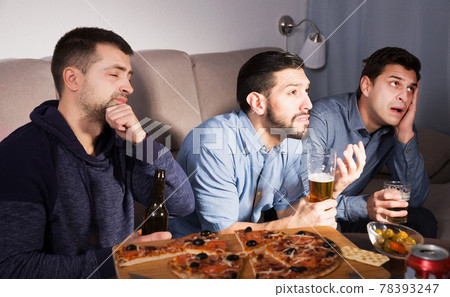 friends in suspense watching tv together at home friends in suspense watching tv together at home 78393247