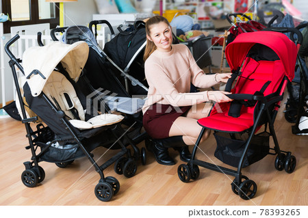 buyer choosing stroller cane in the shop 78393265