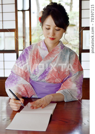 一位穿著浴衣的年輕女子在民居的日式房間裡寫信 一位穿著浴衣的年輕女子在民居的日式房間裡寫信 78397115