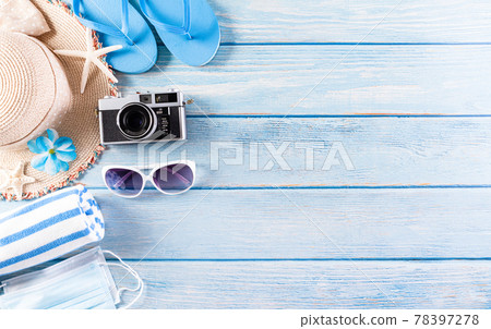 Summer holiday, travel and vacation concept. Sunglasses, starfish, beach hat, seashell and medical mask to protect covid-19 on pastel blue wooden background. Summer holiday, travel and vacation concept. Sunglasses, starfish, beach hat, seashell and medical mask to protect covid-19 on pastel blue wooden background. 78397278