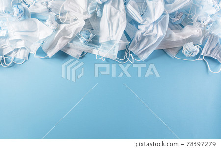 Top view of Covid-19 waste disposable masks on pastelnblue background. Pollution by surgical masks during the coronavirus pandemic. Top view of Covid-19 waste disposable masks on pastelnblue background. Pollution by surgical masks during the coronavirus pandemic. 78397279
