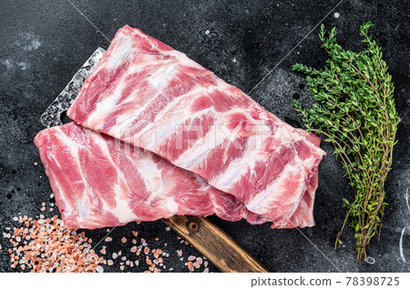 Uncooked Raw pork spare ribs on butcher meat cleaver. Black background. Top view Uncooked Raw pork spare ribs on butcher meat cleaver. Black background. Top view 78398725