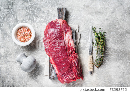 Fresh Flank or flap raw beef steak on wooden board with herbs. Gray background. Top view Fresh Flank or flap raw beef steak on wooden board with herbs. Gray background. Top view 78398753