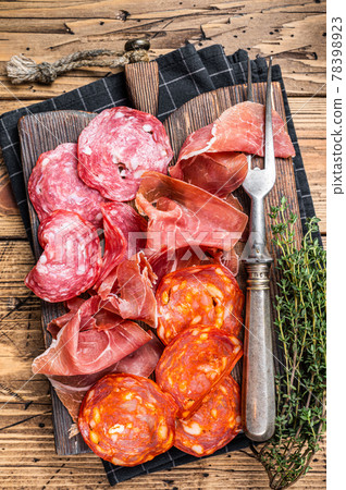 Cured meat platter served as traditional Spanish tapas. salami, jamon, choriso sausages on a wooden board. wooden background. Top view 78398923