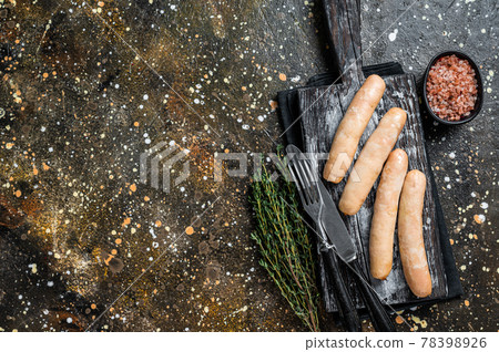 Grilled chicken sausages on a wooden board. Brown background. Top view. Copy space 78398926