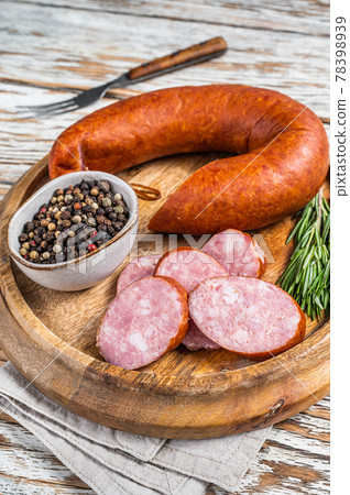 Bavarian Smoked sausage on a wooden board with herbs. White wooden background. Top view 78398939