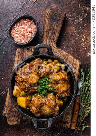 Beef oxtails stew with wine and vegetables in a pan. Dark background. Top view 78398943