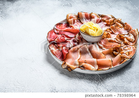 Meat antipasto platter, pancetta, salami, sliced ham, sausage, prosciutto, bacon. Gray background. Top view. Copy space Meat antipasto platter, pancetta, salami, sliced ham, sausage, prosciutto, bacon. Gray background. Top view. Copy space 78398964
