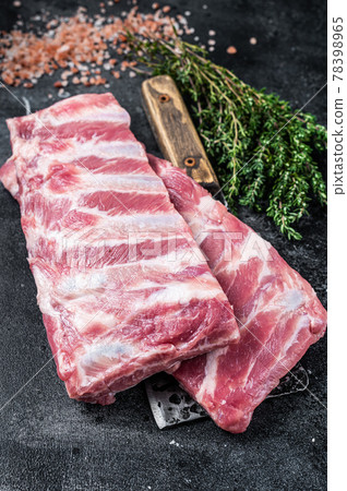 Uncooked Raw pork spare ribs on butcher meat cleaver. Black background. Top view Uncooked Raw pork spare ribs on butcher meat cleaver. Black background. Top view 78398965