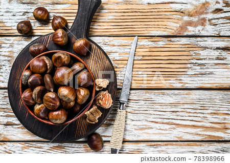 Bowl with chestnuts on a wooden table. White background. Top view. Copy space Bowl with chestnuts on a wooden table. White background. Top view. Copy space 78398966