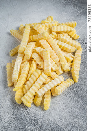 Frozen Crinkle French fries potatoes sticks. White background. Top view Frozen Crinkle French fries potatoes sticks. White background. Top view 78399388