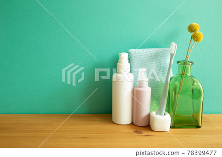 Bathroom bottles, shower towel, toothbrush, vase of plant on wooden table. mint wall background. Skin care and spa concept Bathroom bottles, shower towel, toothbrush, vase of plant on wooden table. mint wall background. Skin care and spa concept 78399477