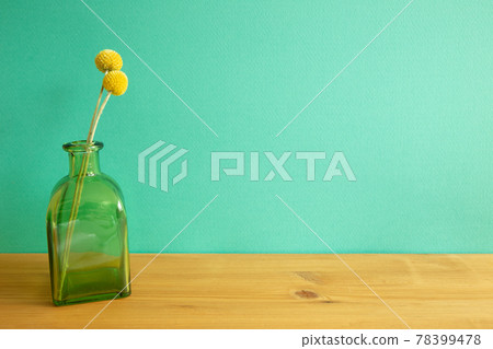 Vase of yellow Craspedia dry flowers on wooden table. mint green wall background Vase of yellow Craspedia dry flowers on wooden table. mint green wall background 78399478