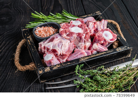 Raw veal beef Oxtail Meat in wooden tray with thyme. Black wooden background. Top view 78399649