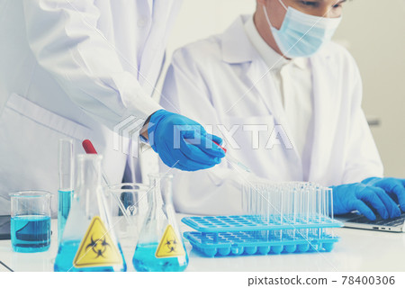 Two asian scientist team reserch chemistry science tube experiment biotech antibody sample in laboratory Cultivate Vaccine against covid-19 virus. Scientist consult, analyze in Chemistry Laboratory 78400306
