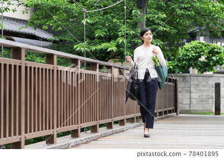 A business woman walking with an eco bag down from her shoulder 78401895