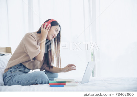Relax woman holding book read on bed using headphone listen music. Young woman relaxation reading open book leisure mind. Happiness beautiful woman person Relax woman holding book read on bed using headphone listen music. Young woman relaxation reading open book leisure mind. Happiness beautiful woman person 78402000
