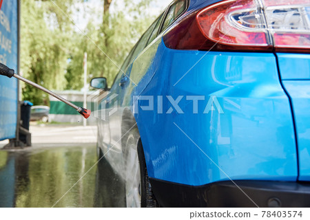 Cleaning car with high pressure water at car wash station Cleaning car with high pressure water at car wash station 78403574