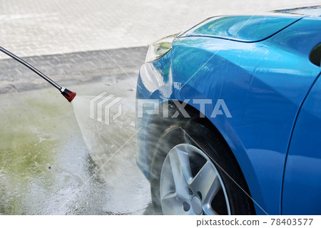 Cleaning car with high pressure water at car wash station Cleaning car with high pressure water at car wash station 78403577