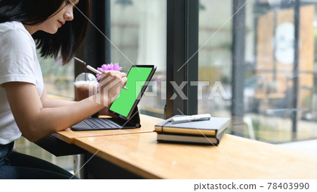 Cropped shot woman using stylus pen writing on tablet with geen screen in office. Cropped shot woman using stylus pen writing on tablet with geen screen in office. 78403990